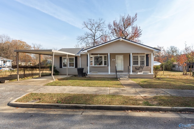 view of front of house with a porch, a carport, and a front lawn