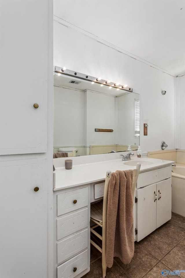 bathroom featuring tile patterned flooring, visible vents, vanity, and a tub to relax in