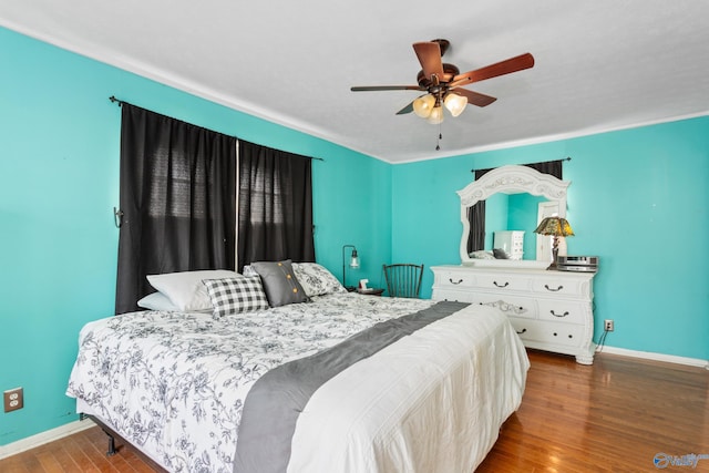 bedroom with ceiling fan, baseboards, and wood finished floors