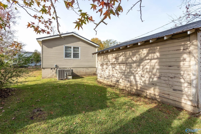 view of property exterior featuring central AC unit and a lawn