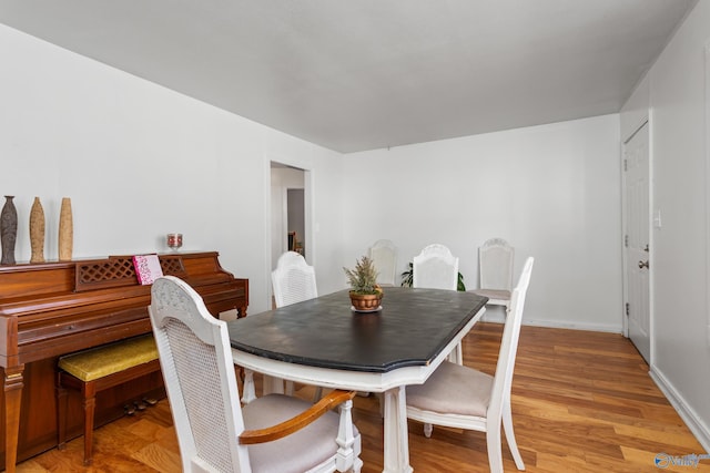 dining area with baseboards and light wood finished floors