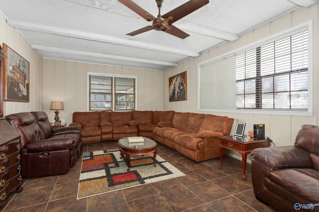 living room featuring a wealth of natural light, beam ceiling, a textured ceiling, and a ceiling fan