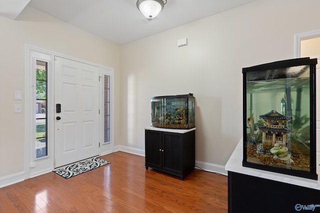 entryway with baseboards and wood finished floors