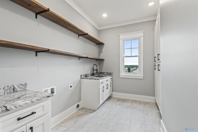 washroom with baseboards, hookup for a washing machine, electric dryer hookup, crown molding, and a sink