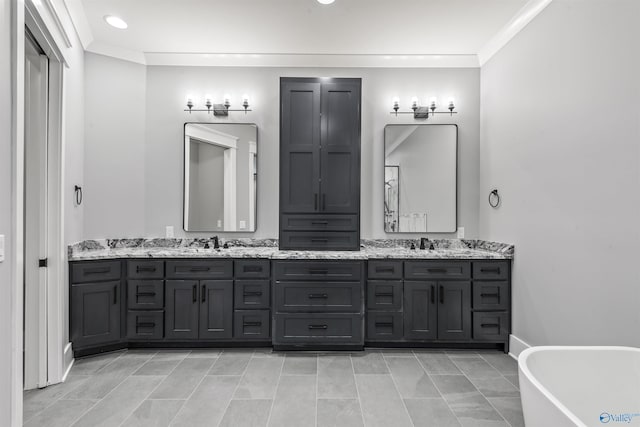 bathroom with double vanity, a freestanding tub, crown molding, and a sink