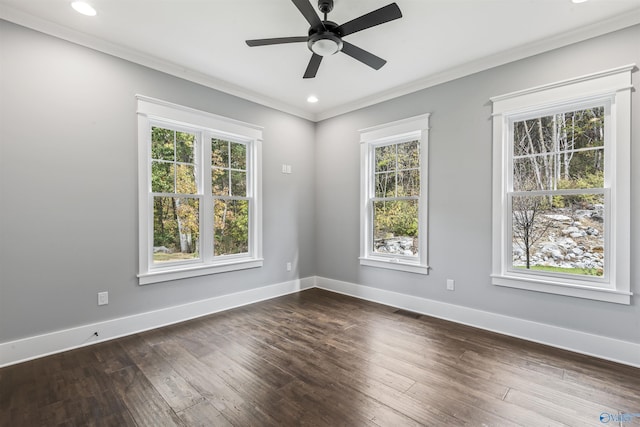 empty room with visible vents, baseboards, dark wood-style flooring, and a wealth of natural light