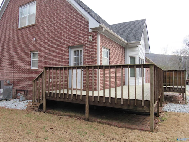 rear view of house featuring a wooden deck and central air condition unit