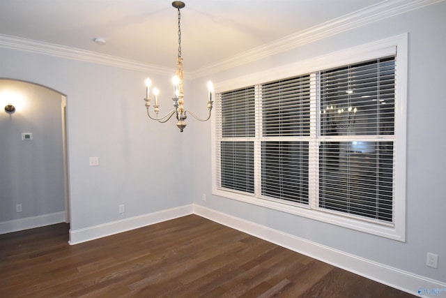 empty room with ornamental molding, a chandelier, and dark wood-type flooring