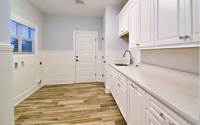 laundry room with washer hookup, hookup for an electric dryer, light wood-type flooring, cabinets, and sink