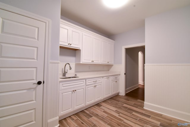 kitchen featuring light wood-type flooring, sink, and white cabinets