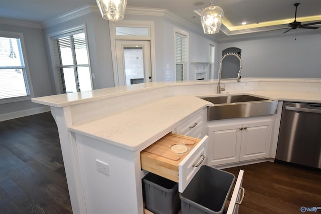 kitchen with hanging light fixtures, sink, stainless steel dishwasher, white cabinetry, and dark hardwood / wood-style floors