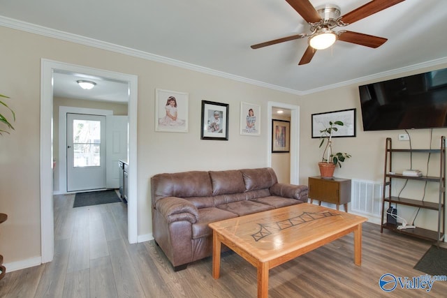 living room with ceiling fan, crown molding, and wood-type flooring