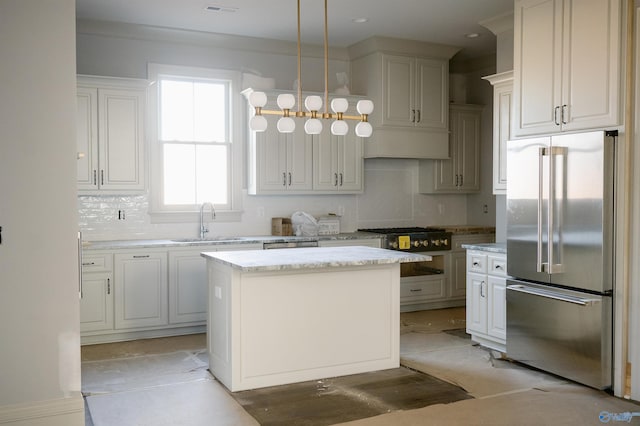 kitchen with sink, white cabinetry, hanging light fixtures, a kitchen island, and high end refrigerator