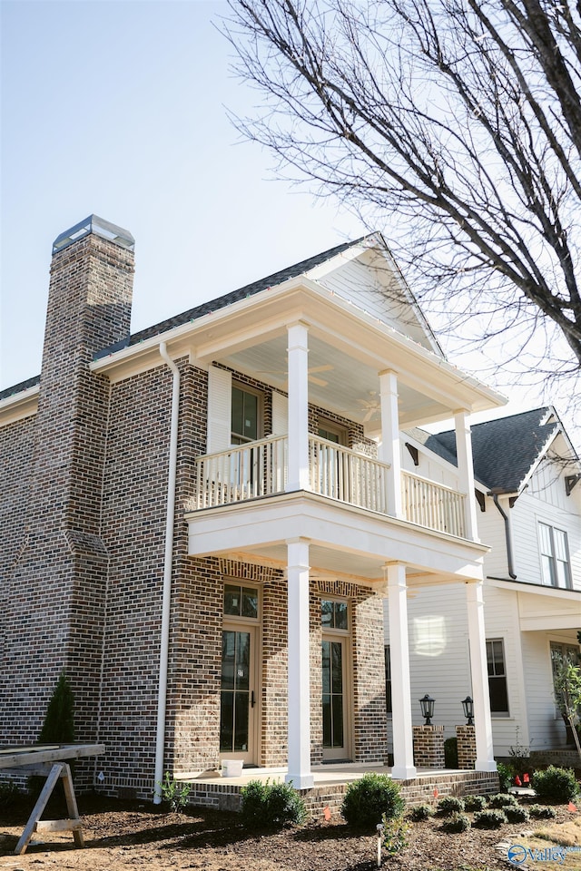 rear view of house featuring a porch and a balcony