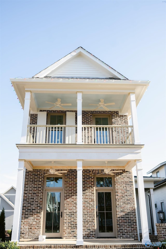 view of front of home with ceiling fan and a balcony