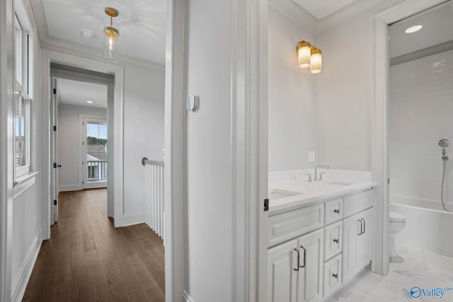 full bathroom featuring wood-type flooring, crown molding, vanity, toilet, and bathing tub / shower combination