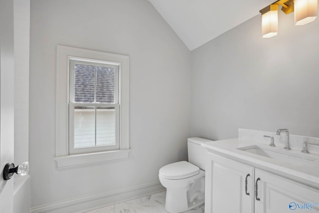 bathroom with vaulted ceiling, vanity, and toilet