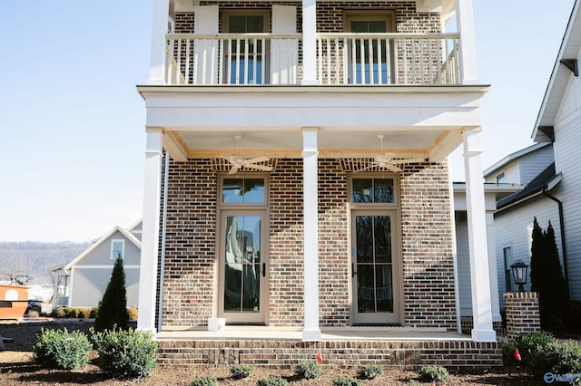 rear view of property featuring a balcony and covered porch