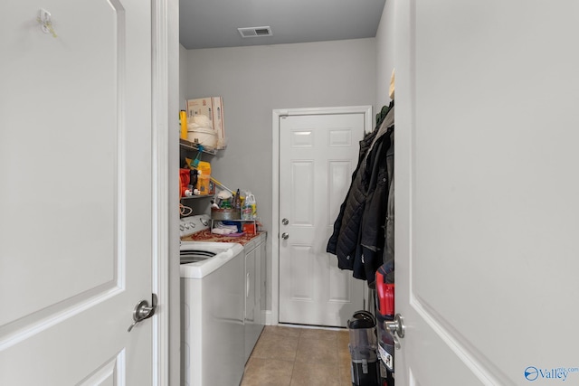 laundry area with light tile patterned floors, laundry area, washing machine and clothes dryer, and visible vents