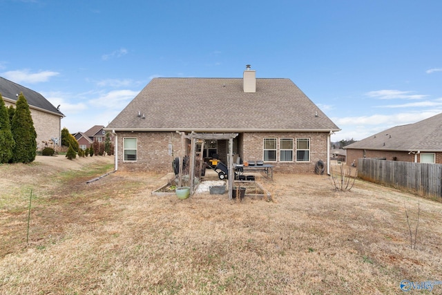 back of house featuring brick siding, a chimney, a patio area, and fence