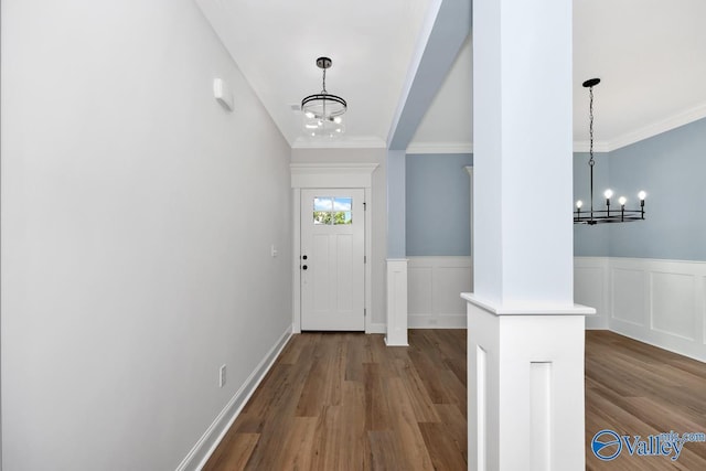 entrance foyer with an inviting chandelier, hardwood / wood-style floors, and ornamental molding