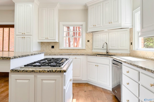 kitchen featuring ornamental molding, appliances with stainless steel finishes, a sink, and white cabinets