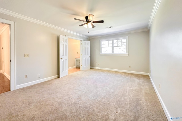 unfurnished bedroom with light colored carpet, visible vents, crown molding, and baseboards