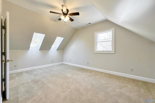 additional living space featuring lofted ceiling, light colored carpet, visible vents, ceiling fan, and baseboards