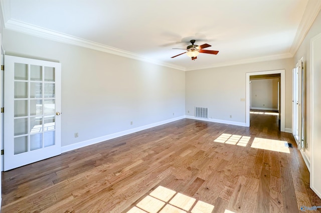 unfurnished room featuring baseboards, visible vents, ceiling fan, ornamental molding, and wood finished floors