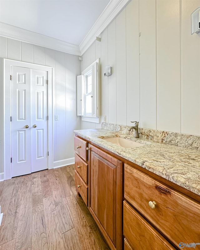 bathroom with crown molding, vanity, and wood finished floors