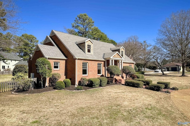 view of front of home featuring a front yard, fence, and brick siding