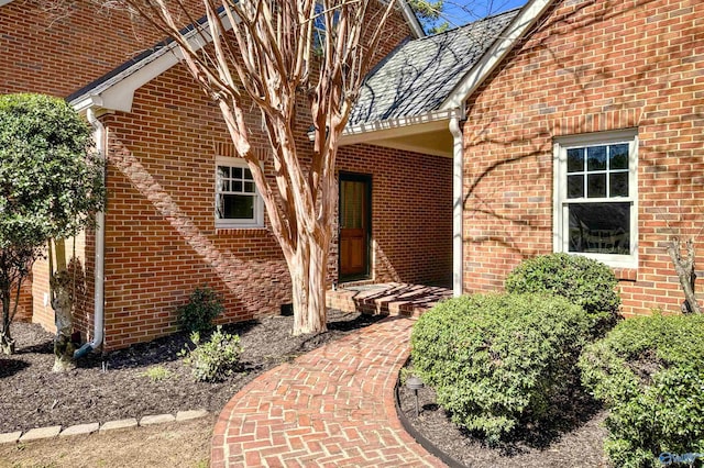 entrance to property featuring brick siding