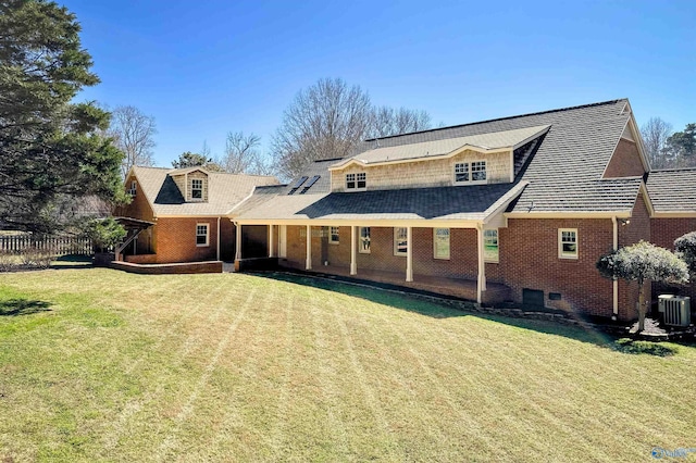 back of house with brick siding, a lawn, fence, and central air condition unit