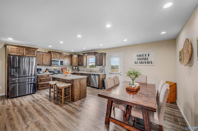 dining room with recessed lighting, wood finished floors, and baseboards