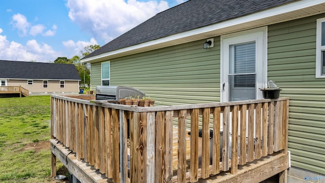 wooden terrace with a lawn and area for grilling