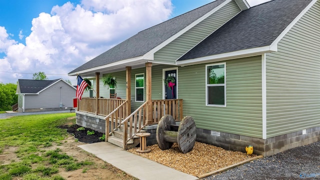 view of front facade featuring a porch, a shingled roof, and crawl space
