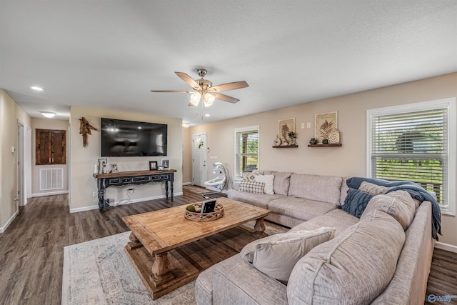 living area with visible vents, ceiling fan, wood finished floors, and baseboards