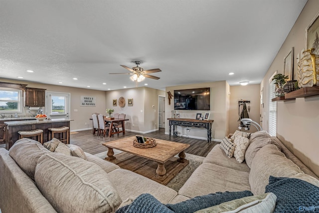 living room featuring wood finished floors, recessed lighting, a ceiling fan, and baseboards