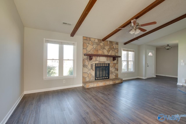 unfurnished living room featuring dark wood-style floors, a stone fireplace, visible vents, and baseboards