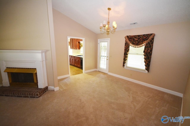 unfurnished living room featuring an inviting chandelier, a brick fireplace, lofted ceiling, and light colored carpet