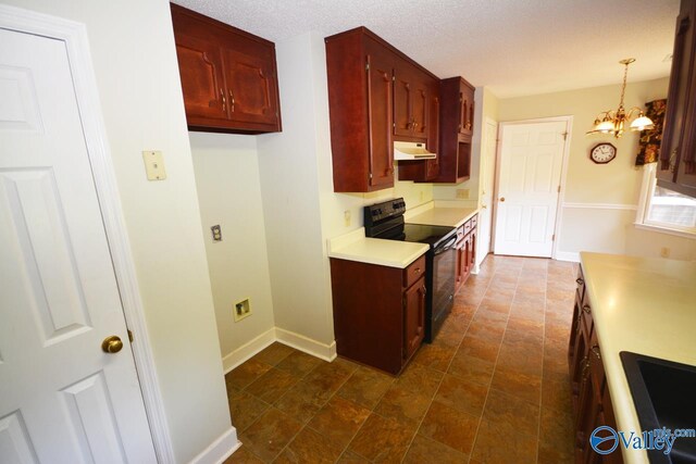 kitchen featuring a chandelier, dark tile patterned floors, exhaust hood, and black range with electric stovetop