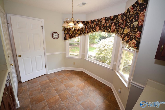 unfurnished dining area with a healthy amount of sunlight and an inviting chandelier