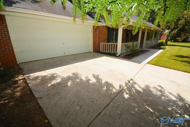 view of front of house featuring a garage, a front yard, and covered porch