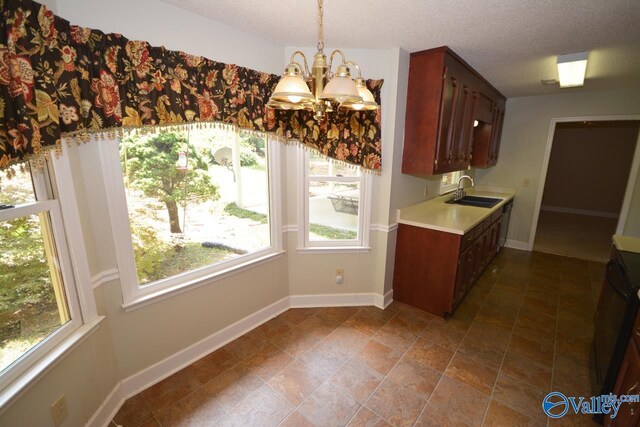 kitchen featuring hanging light fixtures, a wealth of natural light, tile patterned flooring, and a chandelier