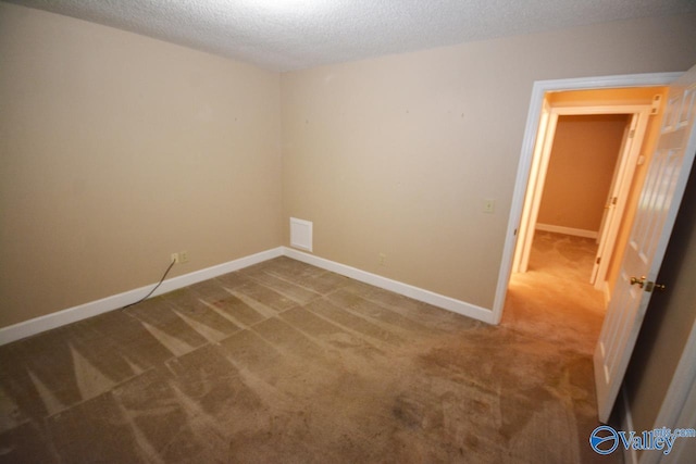 carpeted spare room with a textured ceiling