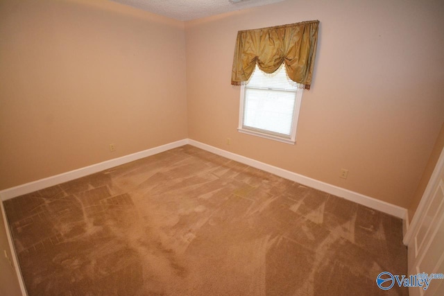 carpeted empty room featuring a textured ceiling