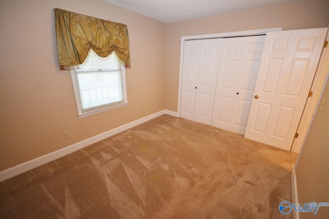 unfurnished bedroom with a closet, a textured ceiling, and carpet