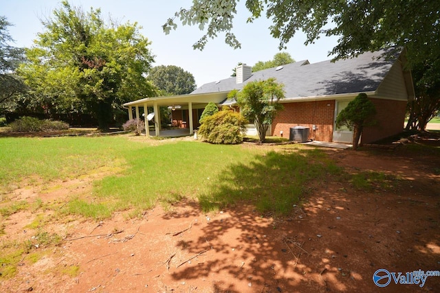 view of yard featuring central AC unit and a patio