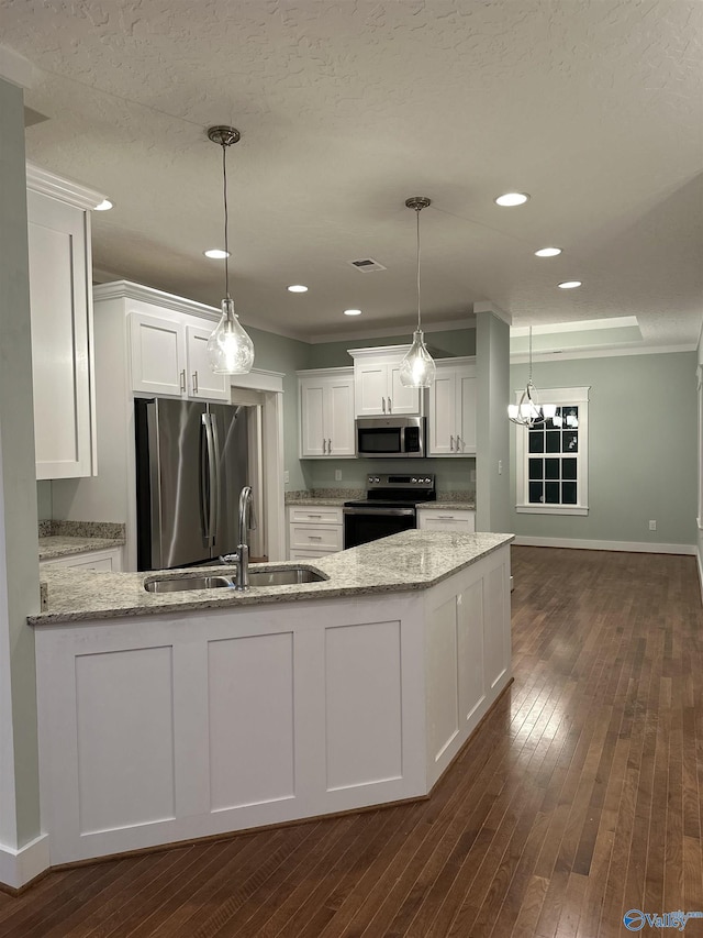 kitchen featuring light stone counters, a sink, white cabinetry, appliances with stainless steel finishes, and dark wood-style floors