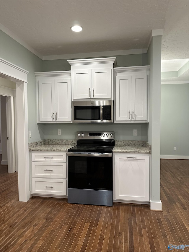 kitchen featuring dark wood finished floors, crown molding, stainless steel appliances, white cabinets, and light stone countertops